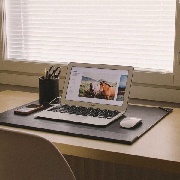 Aufgeräumter Schreibtisch mit Notebook am Fenster