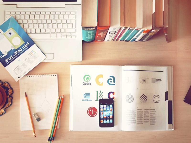 Schreibtisch mit Notizbüchern, Stiften und Unterlagen