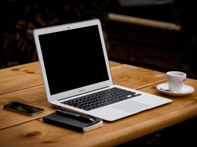 Notebook und Kaffeetasse auf Holztisch